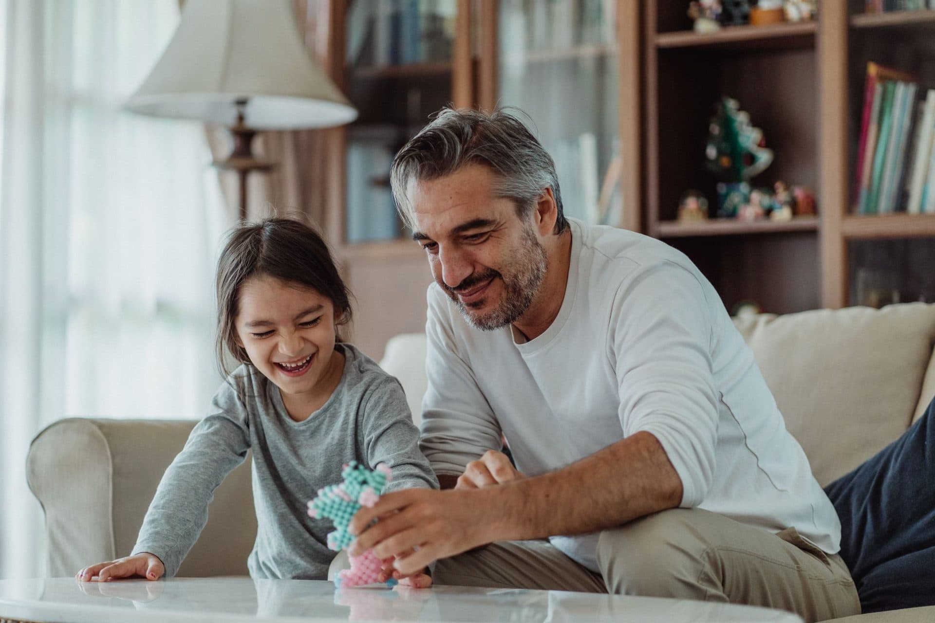 A father and daughter laughing together at home