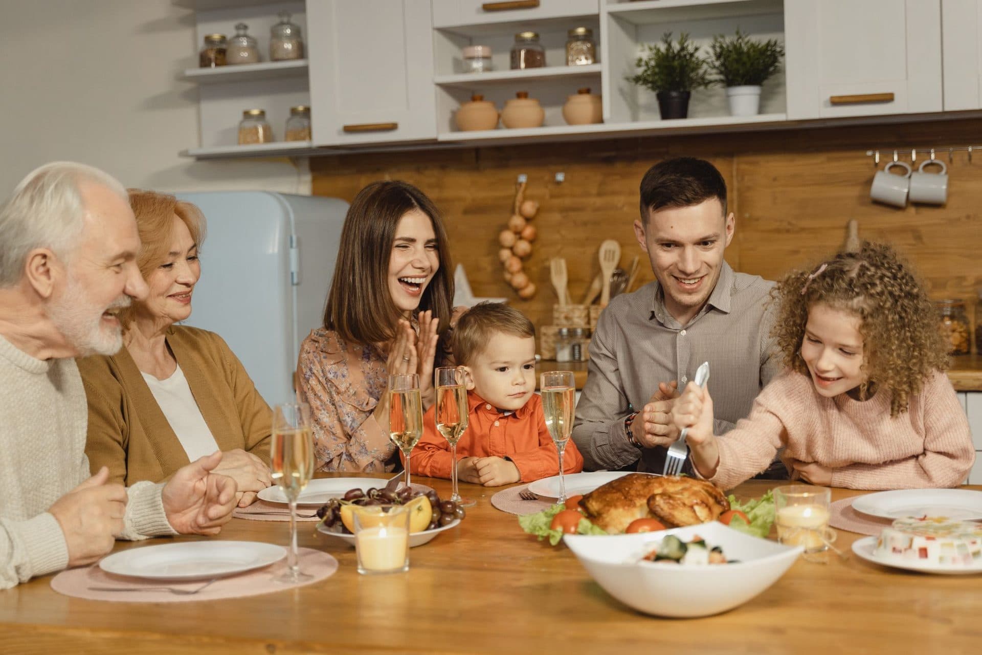 Three generations of a family laughing around the dinner table