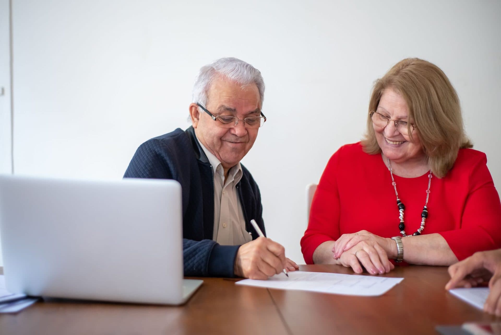 An older couple signing their paperwork together