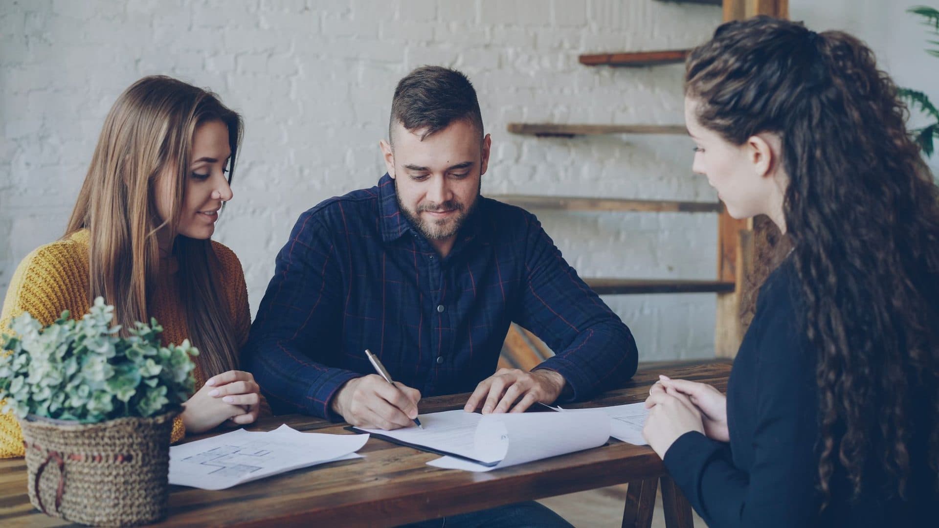 An advisor helping a couple fill in their paperwork