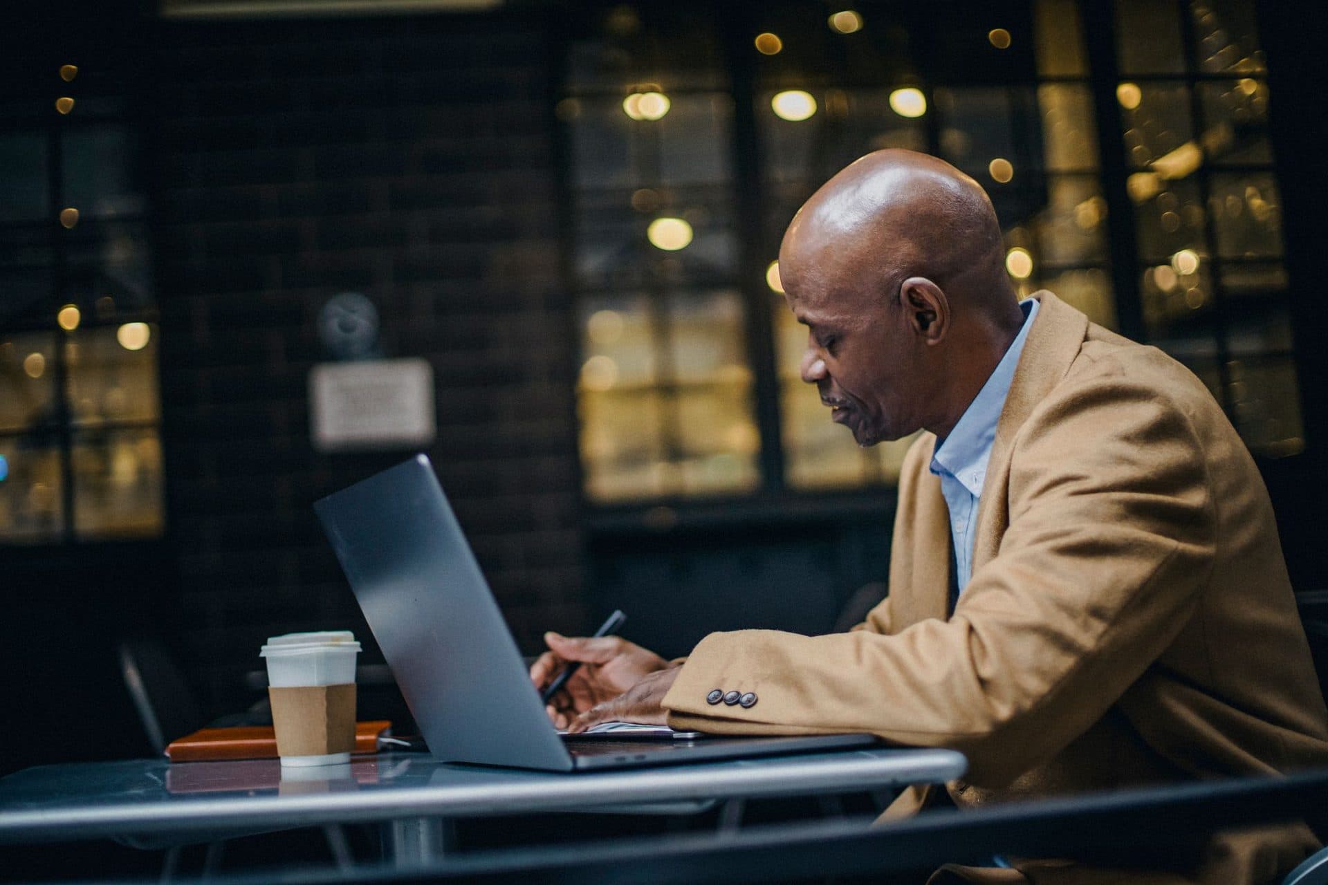 A self-employed professional working on his laptop at a cafe